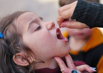 A health worker administers polio vaccine drops to a child during a vaccination campaign aimed at protecting children from preventable diseases. (Photo credit: UNICEF)