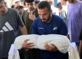 A person holds an image of a victim as Palestinians mourn amid ongoing Israeli attacks and rising casualties in Gaza. (Photo credit: AFP)