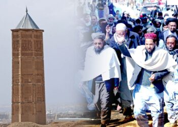 Religious and community leaders march through Ghazni, with the city's historic minaret rising in the background, amid protests over Taliban eviction orders. (Photo credit: AFP)
