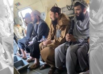 Juma Khan Fateh sits aboard a Taliban helicopter alongside armed fighters as he is transferred to Faizabad after surrendering. (Photo credit: Exclusive)