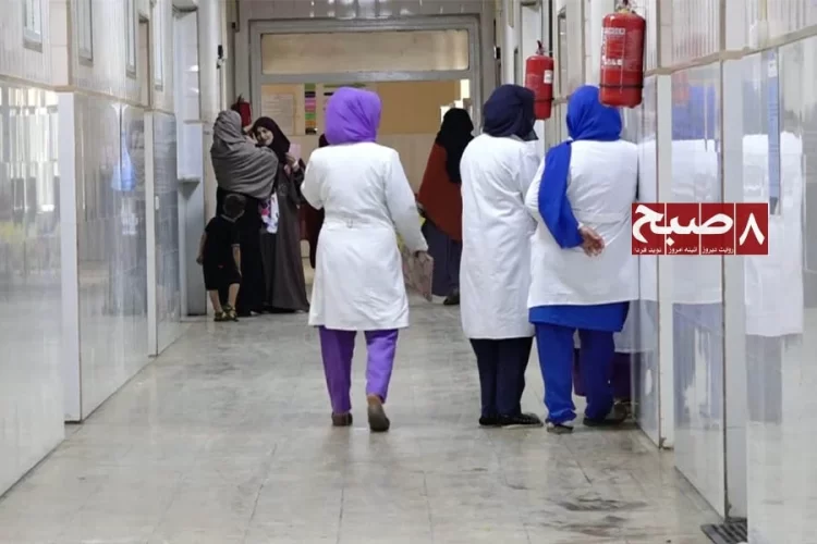 Health workers walk through a hospital corridor in Kabul as patients and caregivers wait nearby amid complaints of overcrowding and neglect. (Photo credit: 8am.media)