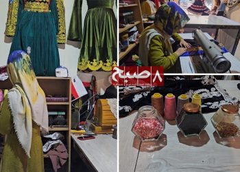 A tailor works at her sewing machine in a Kabul workshop as raw material shortages disrupt Afghanistan's clothing industry. (Photo credit: 8am.media)