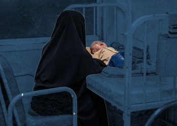 A mother sits beside her child on a hospital bed, reflecting the health challenges many families in Afghanistan face amid limited access to care. (Photo credit: AFP)