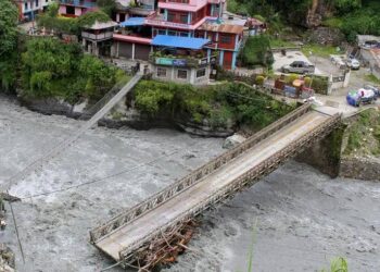 Floodwaters surge through a community in Nepal, surrounding bridges and threatening homes near the river (Photo: REUTERS)