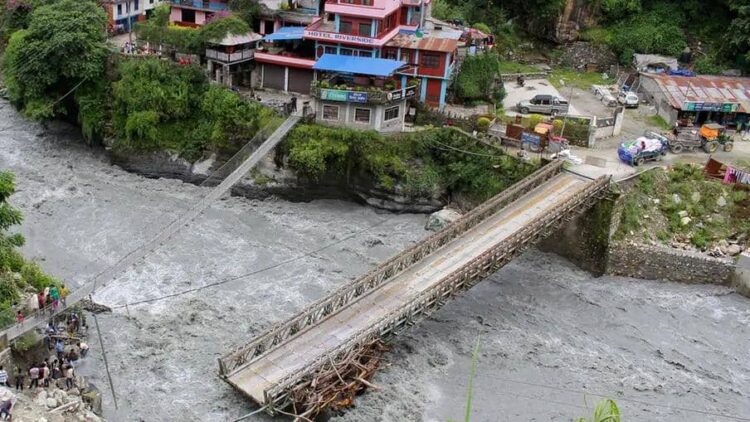 Floodwaters surge through a community in Nepal, surrounding bridges and threatening homes near the river (Photo: REUTERS)