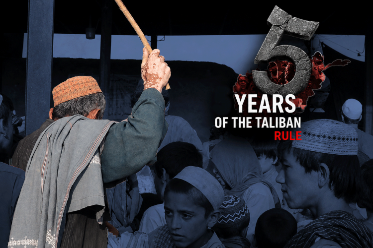 A man raises a stick over a crowd of children and elders in Afghanistan, marking five years since the Taliban took power. (Photo credit: AFP)
