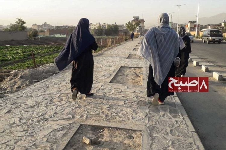 Two women walk along a stone path on the outskirts of Kabul after gyms were closed to them under Taliban restrictions. (Photo credit: 8am.media)
