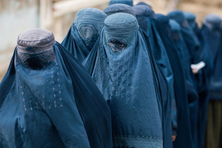 Women wearing burqas walk through a street in Afghanistan amid ongoing restrictions on women’s rights. (Photo credit: Pexels)