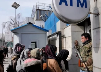 People wait in line at an ATM outside a bank in Kabul as concerns over deposit security shake public trust. (Photo credit: AP)