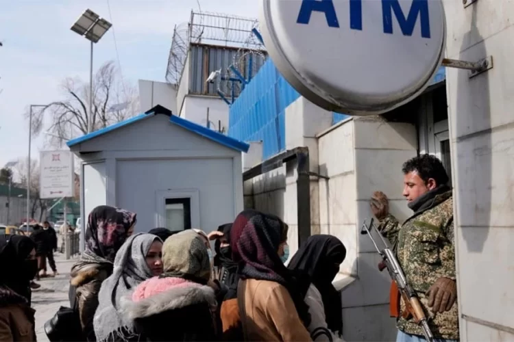 People wait in line at an ATM outside a bank in Kabul as concerns over deposit security shake public trust. (Photo credit: AP)
