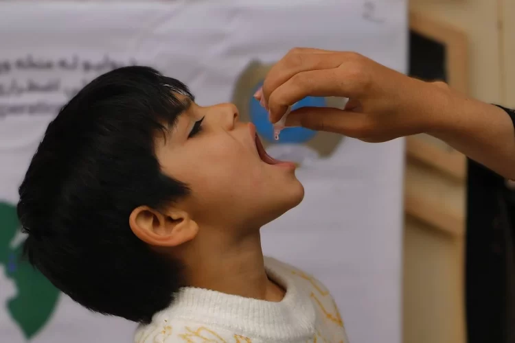 A child receives a drop of polio vaccine during a vaccination campaign in Afghanistan. (Photo credit: UNICEF)