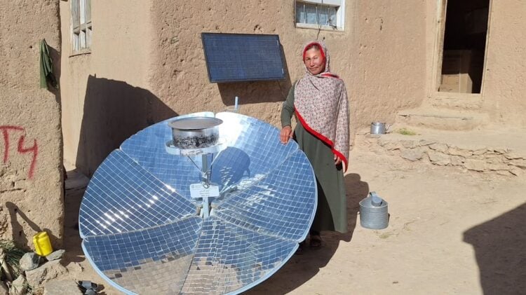 A woman stands beside a solar-powered water system installed outside a rural home (Photo: @FAOAfghanistan)