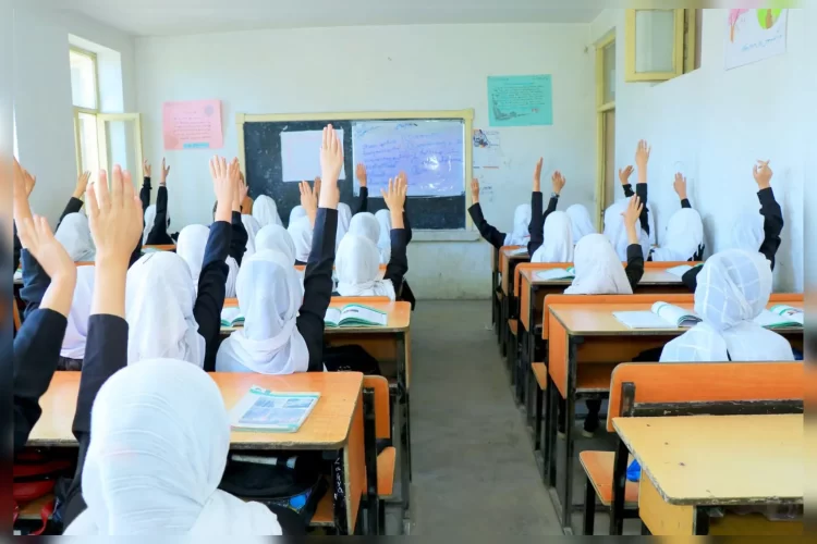 Girls raise their hands during a class as restrictions continue to limit access to education in Afghanistan. (Photo Credit: Social Media)