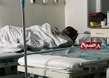 A patient rests on a bed at a government hospital in Kabul, as citizens complain that treatment costs now differ little from private clinics. (Photo credit: 8am.media)