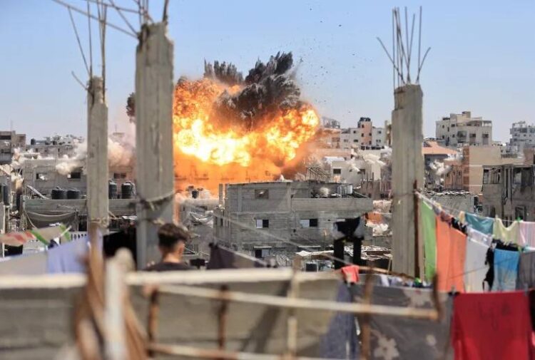 An explosion rises over a densely populated area of Gaza following an Israeli airstrike. (Photo credit: Reuters)
