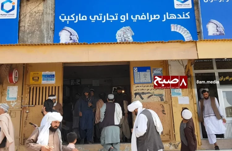 People gather outside the Kandahar money exchange market following the arrest of several money changers and employees. (Photo credit: 8am.media)