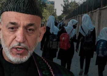 Former Afghan President Hamed Karzai speaks as girls wearing backpacks walk to school along a Kabul street. (Photo credit: Getty Image + AFP)
