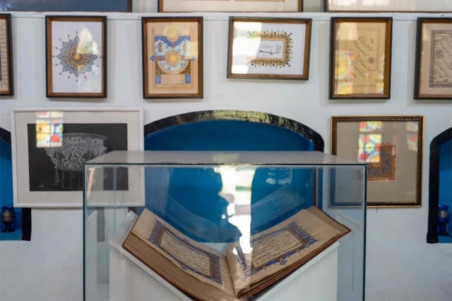 An illuminated manuscript is displayed alongside calligraphy artworks at Naiko Arts in Herat. (Photo credit: Exclusive)