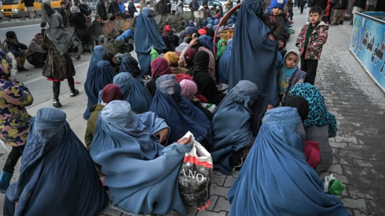 Afghan women and children gather at a crowded public area, with many women wearing blue burqas (Photo: Afghanistan Analysts Network)