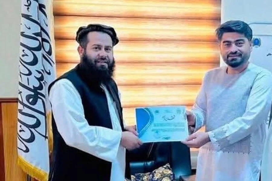Qari Atiq, the Taliban's public health director in Badakhshan, presents a certificate to a man during an official ceremony. (Photo credit: 8am.media)