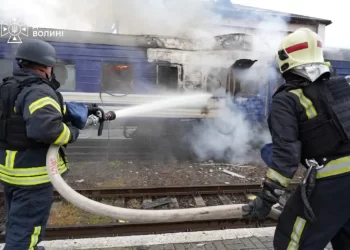 Firefighters extinguish a damaged train carriage following an attack, as smoke rises from the damaged structure (Photo: Reuters)