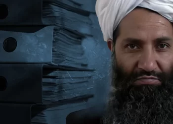 A composite image shows a Taliban leader beside stacks of case files, symbolizing years of unresolved judicial backlogs under Taliban courts. (Photo credit: Wikipedia + Magnific)