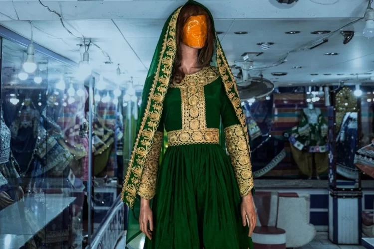 A traditional embroidered green dress is displayed on a mannequin at a handicraft shop, reflecting Afghanistan's declining handicraft sales market. (Photo credit: AFP)