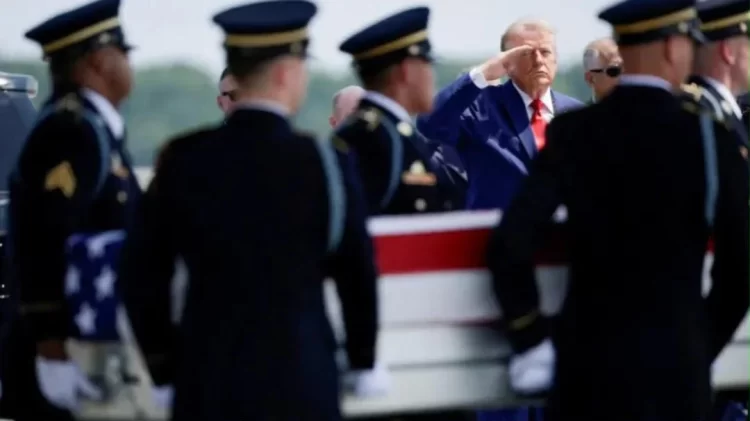 Donald Trump salutes beside the body of a US soldier killed in the war with Iran. (Photo credit: Reuters)