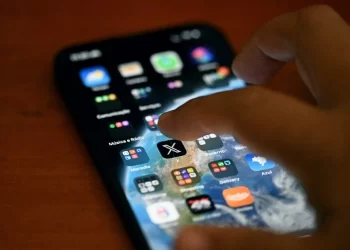 A person scrolls through social media apps on a smartphone (Photo: MAURO PIMENTEL / AFP)
