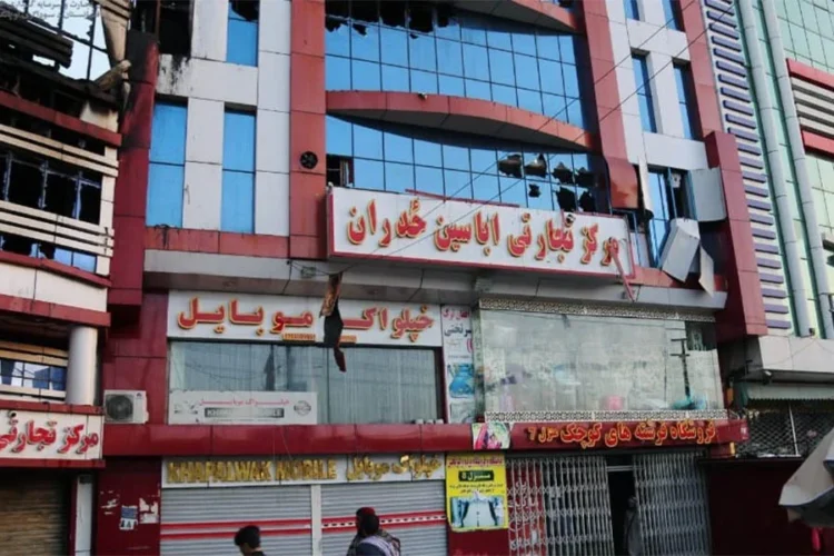 A multi-storey red commercial building with shattered windows and a damaged “Abaseen Zadran” signboard stands in Kabul. (Photo credit: Social Media)