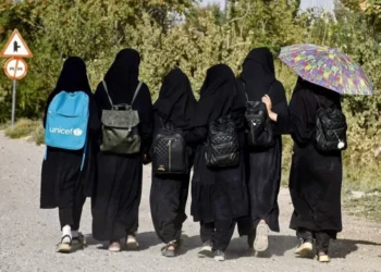 A group of Afghan girls walking with their backs to the camera (Photo: AFP)