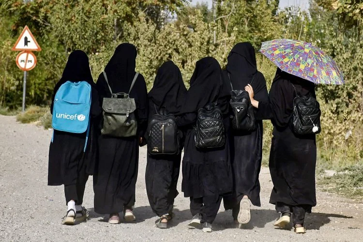 A group of Afghan girls walking with their backs to the camera (Photo: AFP)