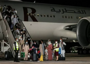 Afghan migrants disembark from an airplane at night (Photo: KARIM JAAFAR)