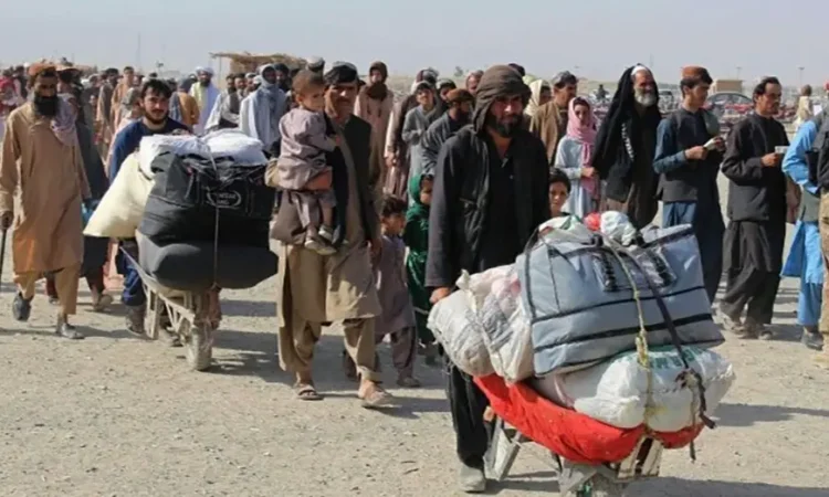 A group of Afghan migrants returning with their belongings