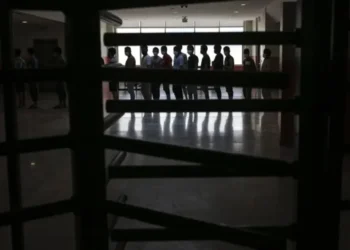 Afghan asylum seekers stand inside a building, silhouetted against the light from the windows, amid concerns over possible deportations from the United States (Photo: AP)