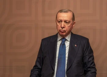 Turkish President Recep Tayyip Erdogan sits in a suit during an official event. (Photo credit: MARCO SIMONCELLI / AFP)