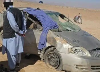 A damaged car is seen in the area of accident with people standing around (Photo: bakhtarnews)