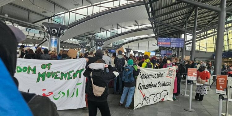 Demonstrators hold banners in German during a protest against the forced deportation of asylum seekers in Germany. (Photo credit: Exclusive)