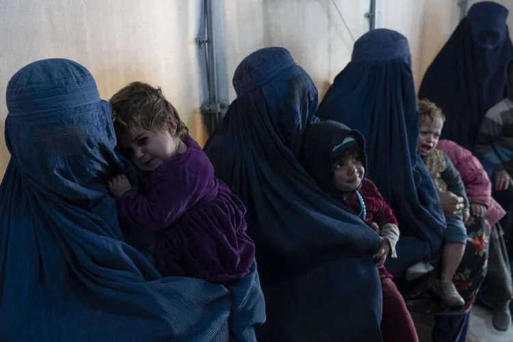 A group of women in burqas walk through Herat amid worsening economic hardships and concerns over meeting basic needs. (Photo credit: AFP)