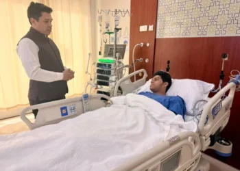 A patient laying in a hospital bed with a visitor talking to him (Photo: @IndianEmbRiyadh/X)