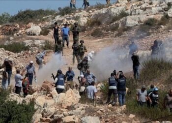 Israeli security forces and civilians gather on a rocky hillside amid clouds of smoke during a confrontation (Photo: FILE)