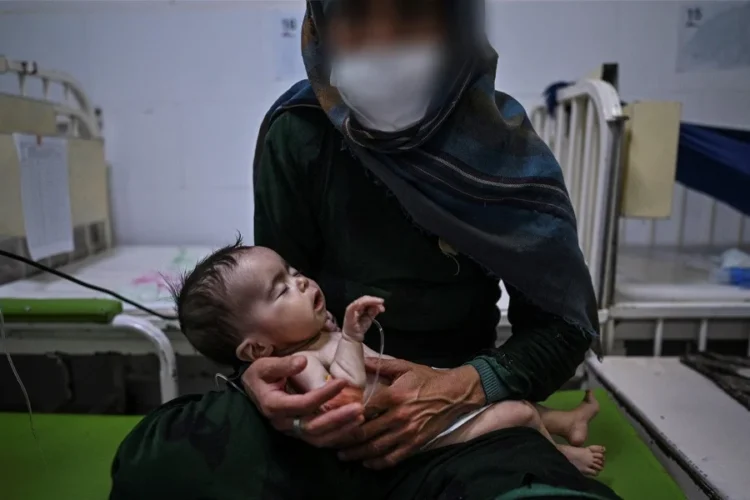 A mother holds her infant in a hospital ward in Afghanistan as doctors warn that postpartum depression often goes unnoticed. (Photo credit: AFP)
