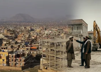 Taliban members stand near an unfinished building and an excavator, with a view of densely built homes in Kabul’s Omid-e Sabz Township. (Photo credit: Social Media + AI)