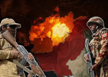 Two armed soldiers stand on either side of a burning map of Afghanistan as tensions between Pakistan and the Taliban deepen. (Photo credit: AFP + Magnific)