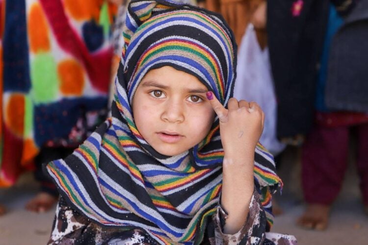 A little girl posing for the camera showing her marked finger for polio vaccination (Photo: @PolioFreeAfghan)