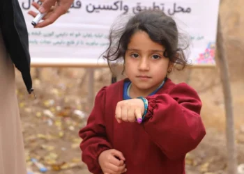 A child wears a polio awareness ribbon on her wrist during a vaccination campaign. (Photo credit: @PolioFreeAfghan)