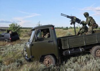 A military truck carrying two soldiers and a mounted machine gun during military operations. (Photo credit: TASS)