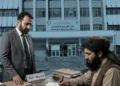 A former prosecutor stands beside a Taliban official reviewing case files in front of the Attorney General’s Office in Kabul. (Photo credit: tkg.af + AI)