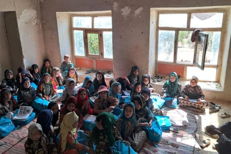 Girl students sit on a carpeted floor in a mud-walled classroom in Tulak district of Ghor amid a shortage of school buildings and textbooks. (Photo credit: Exclusive)