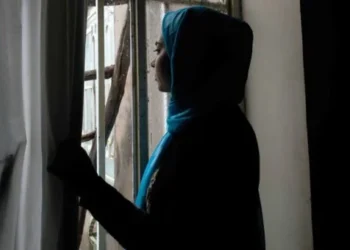 A woman standing in front of a window staring ahead (Photo: UN)